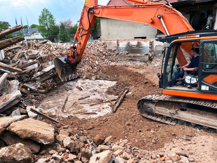 Bagger schaufelt auf einer Fläche ein Loch in dem Boden
