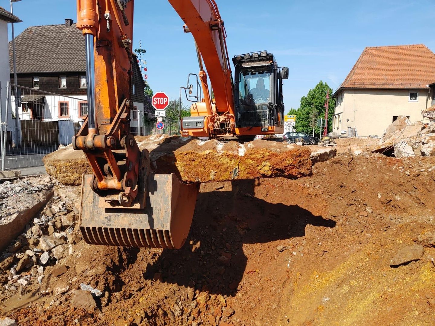 Bagger schaufelt ein Loch in einem sandigen Boden