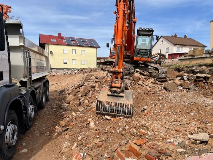 Schaufel eines Baggers lädt Geröll auf einen Wagen